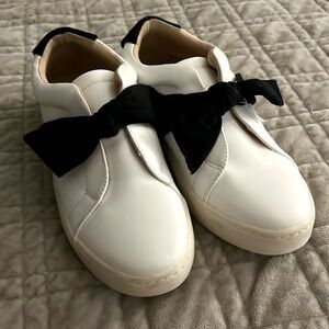 White comfort shoes with a black bow.